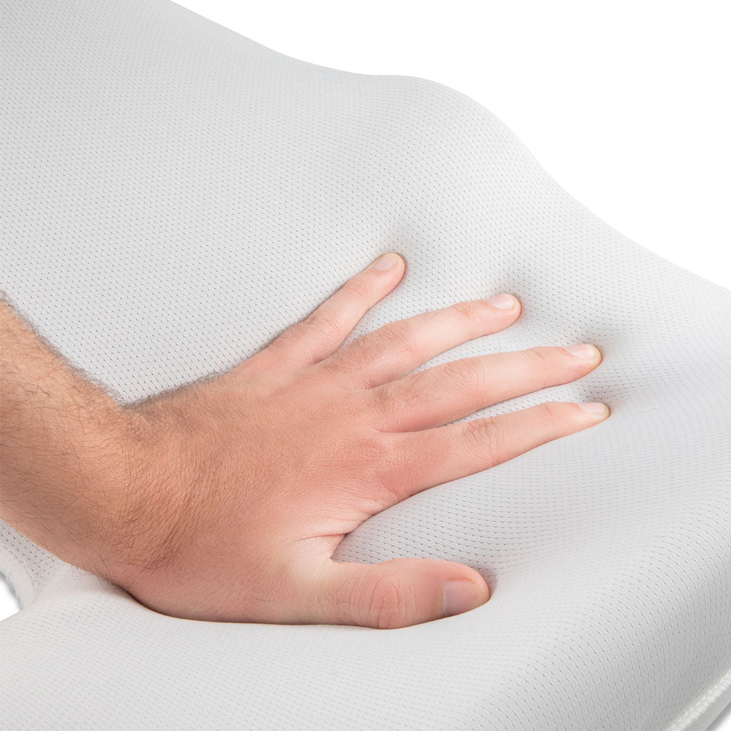 Man's hand pushing seat cushion's foam showing memory foam effect